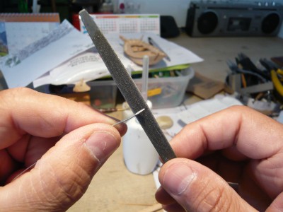 Con una lima de grano fino, desbasto los laterales del aplastamiento hasta hacer una pletina de 0,7 mm de ancha y su extremo, lo afilo a modo formón. El filo de esta pletina no se aprecia en la foto.