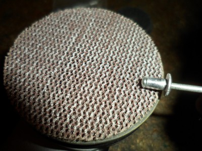 Siguiente paso lijado de la cabeza del remache este paso es necesario para rebajar un poco el paso por el ojal del disco de vellón con una herramienta rotativa y una lija se lija rápido recuerdo que la cabeza es de aluminio fácil de lijar. lijaremos un poco sin pasarnos comprobando el paso que sea forzado pero no mucho que pase vamos.