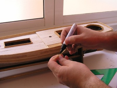 Calafateando la cubierta, pintando los bordes para que resalten.