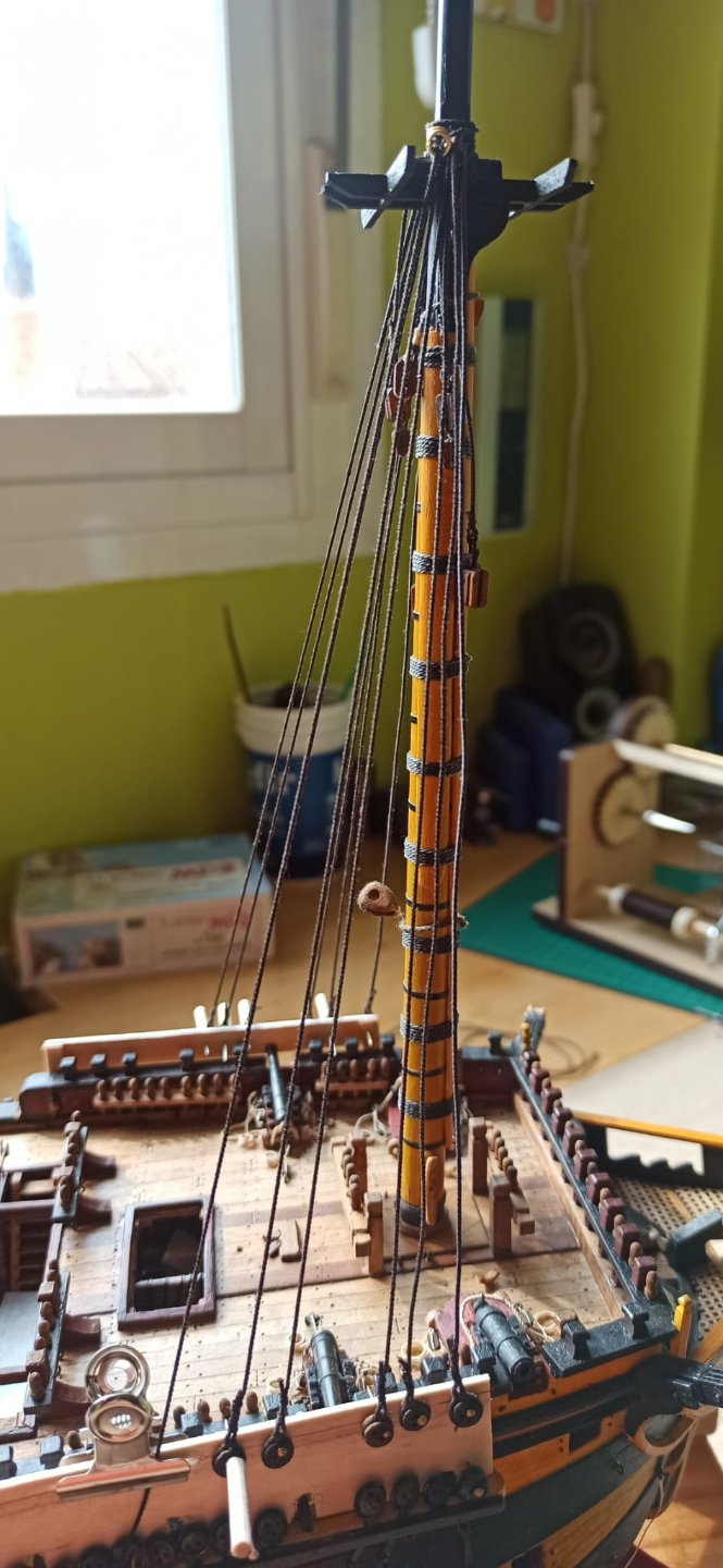 Una vez hecha, la presento en el barco, y subo el centro del cabo hacia arriba, en la gaza, pongo una arandela de hilo latón para cerrar y ajustar bajo el chicote sin vigota y lo sujeto en su posición en la mesa.