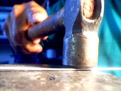 tomo un trozo de alambre galvanizado y lo martillo en el yunque para aplanarlo, este material lo voy a emplear para hacer los travesanios que van en el cuerpo del cabestante (seguro tienen un nombre pero desconozco), estos travesanios sirven para frenar l