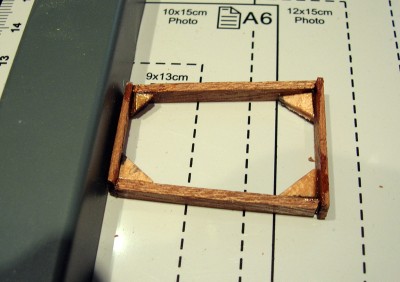 El tambucho tiene forma trapezoidal, más estrecho en popa.<br />Los listones laterales son más estrechos para poder redondearlos un poco, siguiendo la brusca.<br />Las calzas de las esquinas dan consistencia al marco.