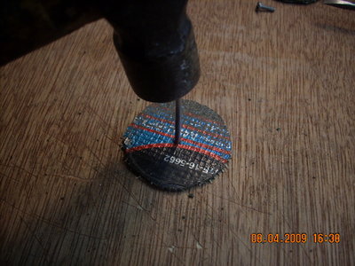 LUEGO CLAVAMOS UN CLAVO DE ACERO EN EL CENTRO DEL DISCO PARA HABILITAR LA PERFORACION POR DONDE PASA EL TORNILLO DEL MANGUITO DEL TORNO.