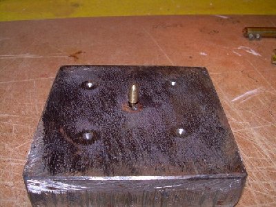 ponemos una base solida yo uso un trozo de hierro al que le he hecho un agujero para pasar el eje y de paso subirla un poco con unos trozos de palillos hasta la altura deseada