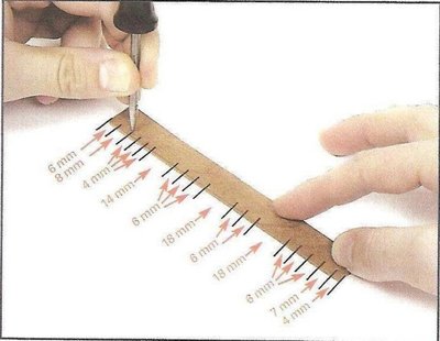 Con la ayuda de una regla y de un punzón, trazaremos las marcas que nos muestra la imagen, a 2 mm de distancia del lateral recto del listón.