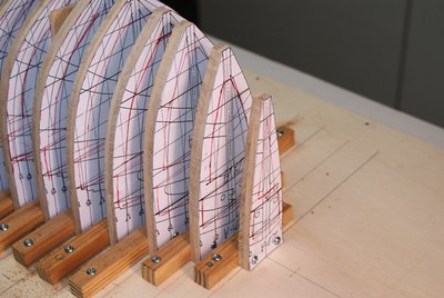 Cuadernas fijadas sobre la grada de construcción. Observad que el centro de la quilla coincide con la línea central de la grada y que cada cuaderna coincide en su centro, con su línea correspondiente.  Las líneas de rotulador rojo, identifican la zona que mas tarde cortaré para dejar hueco el interior.