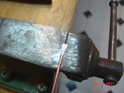 Machaco el alambre de cobre sobre el tornillo de banco dejándolo un poco abierto, de este modo por la parte inferior se forma el nervio