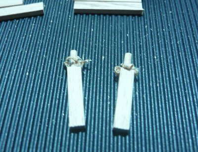Mini eje fresado por un lado, luego hay que quitar la rebaba, para esto utilice una tablilla de espesor igual a la longitud final del eje, taladre orificios de 2 mm e introduje el mini eje, recortando con un cutter , y a la vez lijando el mini eje hasta igualar el espesor de la tablita (consiguiendo el largo deseado)
