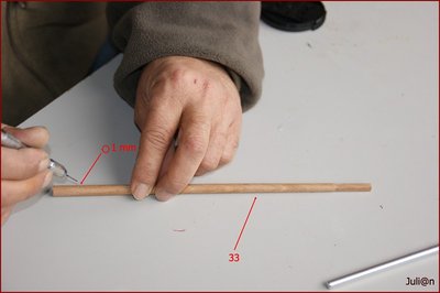 Con una varilla de sapelly de 8 mm de diámetro, elaboraremos el mastelero del trinquete (pieza Nº33). Es muy importante que tomemos las medidas del plano y que te fijes en los rebajes antes de proceder. Después, con un taladro y una broca de 1 mm, practicamos los orificios que nos indican las figuras del plano.