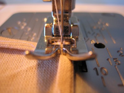 Empiezo a coser, pongo la tela y bajo el prensatelas, aplico fuerza al pedal y la propia máquina hacer correr la tela, nunca debemos tirar de ella porque si lo hacemos no coserá recto, hará ondulaciones, además del riesgo de partir la aguja