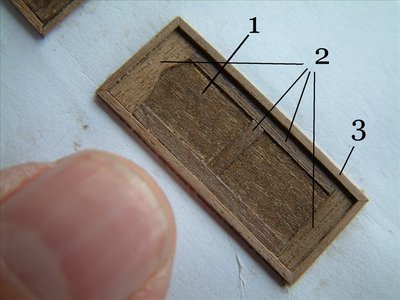 Veréis que las puertas tienen varios niveles que mostramos en la foto 2. El nivel 1º es el más bajo y corresponden al cuerpo de la puerta. El 2º corresponde a las molduras y la 3ª a los marcos.<br /><br />Hay que estudiar el orden del proceso de pegado. Debemos empezar por el nivel más bajo. En la foto 3 hemos comenzado por las molduras cuando deberíamos haber empezado por el fondo. Esto se debe hacer así para, una vez acabado de pegar todas las piezas, ir lijando el conjunto. Si ponemos una pieza de nivel superior su mayor tamaño no permitiría el lijado de la parte más baja. Por otro lado, es más fácil colocar las siguientes piezas sin que aparezcan holguras. En el caso de la foto 3 es más difícil ajustar la chapa que irá en el fondo.